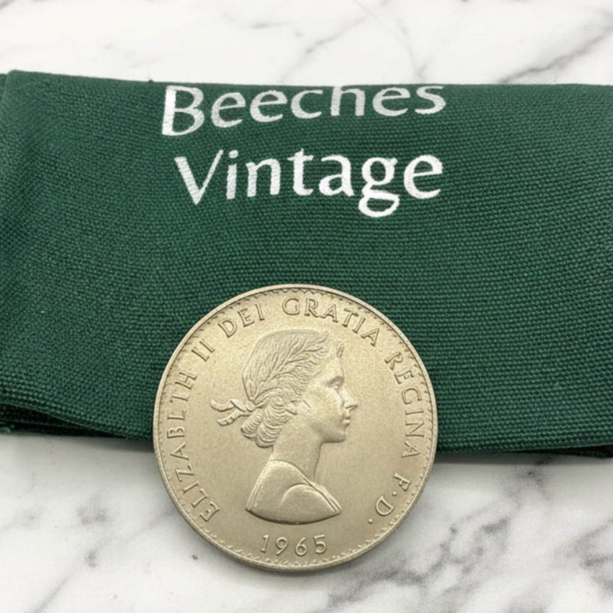 Vintage coin with 'Beeches Vintage' label on a marble surface