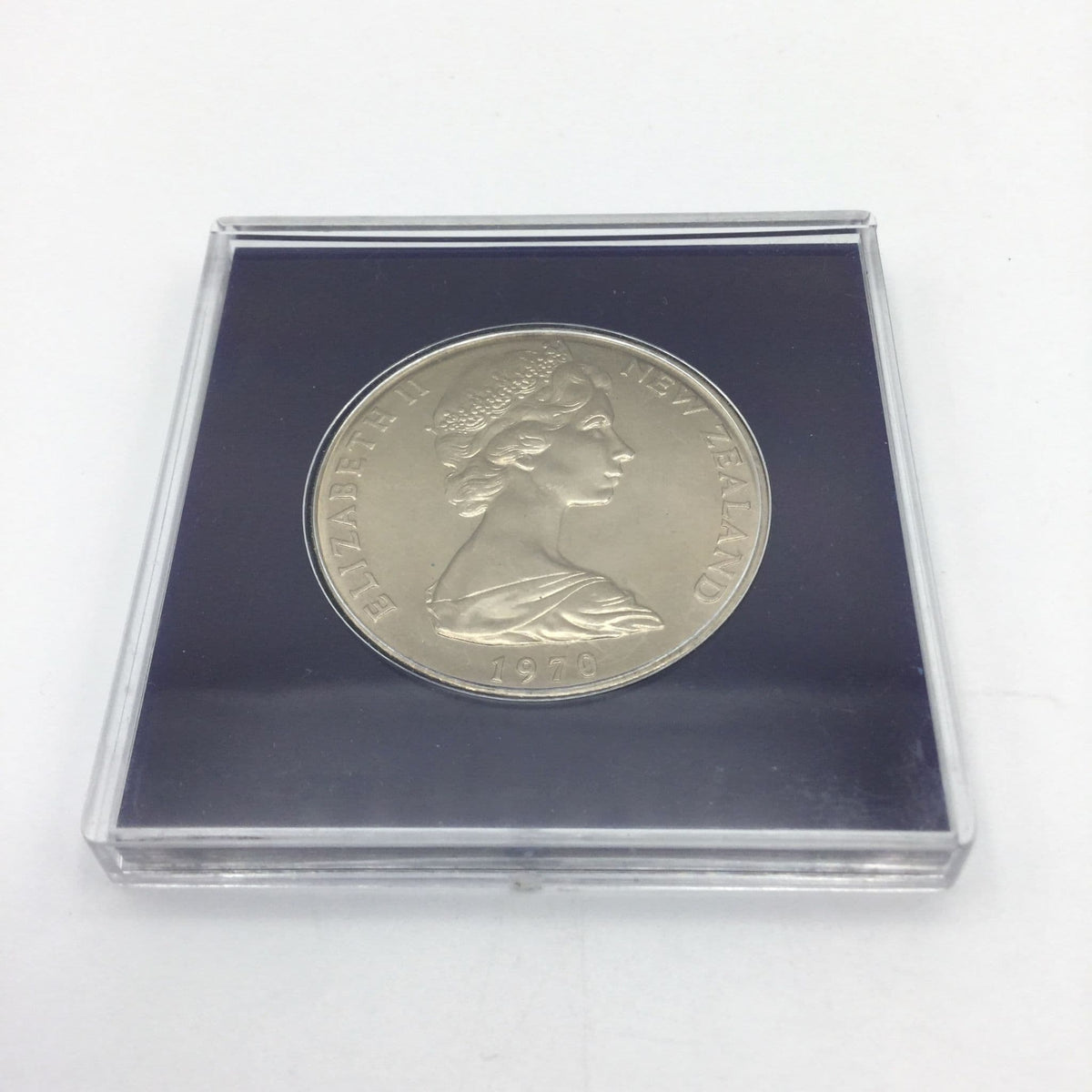 Reverse side of Cook Islands dollar coin with a ship on it in a blue case