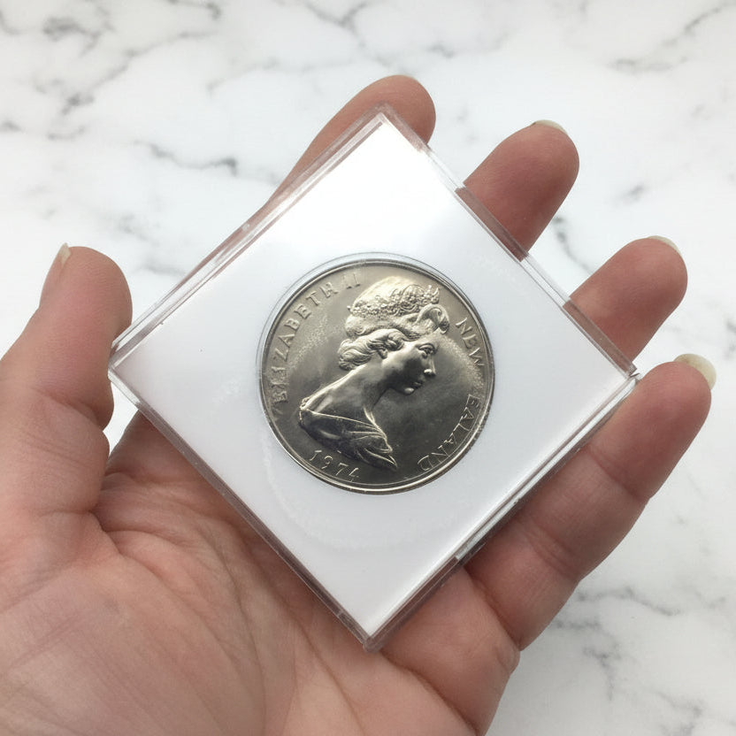 One dollar coin in a white case held in a hand