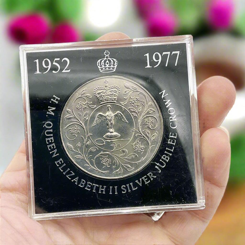 silver crown coin in a black case with HM Queen Elizabeth II Jubliee Crown held in a hand