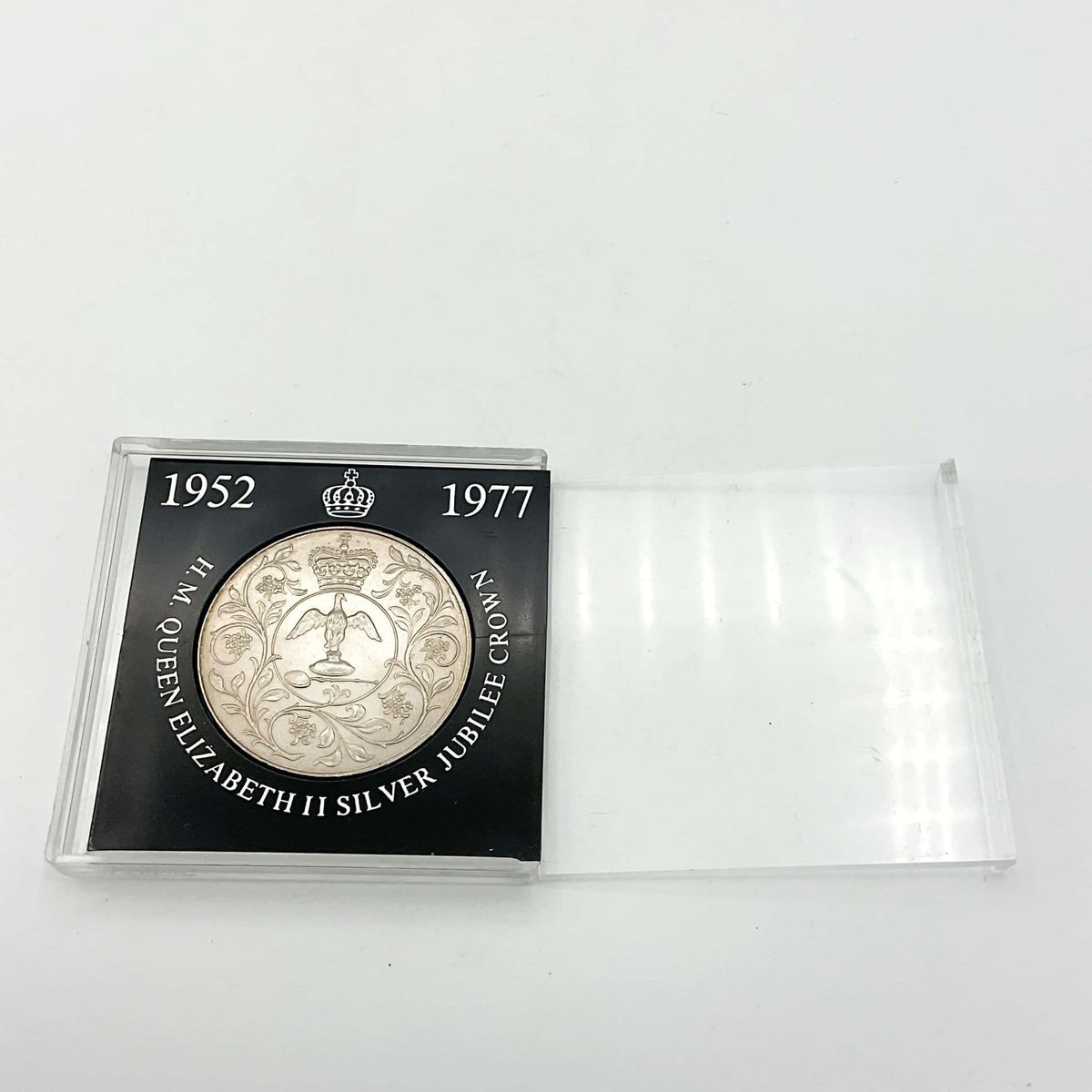 silver crown coin in a black case with HM Queen Elizabeth II Jubliee Crown with the perspex cover slid to the side