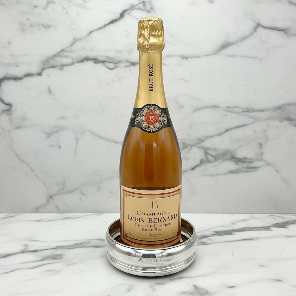 Bottle of Champagne Louis Bernard in a silver bottle coaster on a marble surface