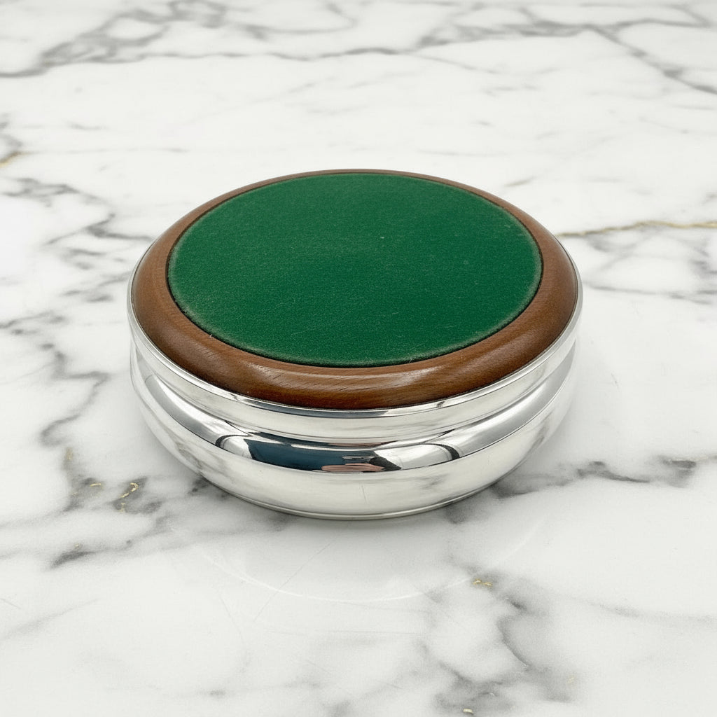 Green felt base of silver wine coaster on a marble worktop