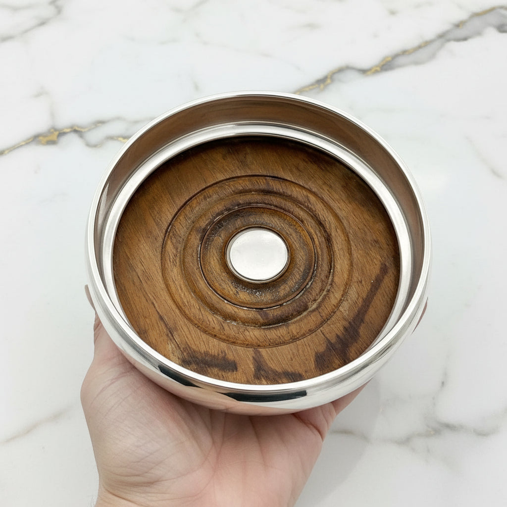wood interior of wine bottle coaster showing stains, held in a hand on a marble worktop