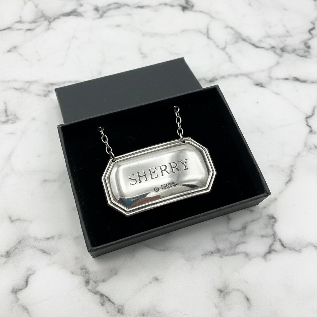 Sherry decanter label with hallmarks in a black gift box on a marble worktop
