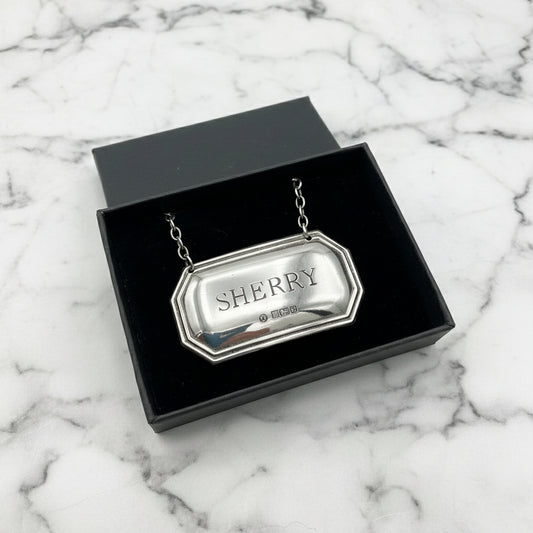 Sherry decanter label with hallmarks in a black gift box on a marble worktop