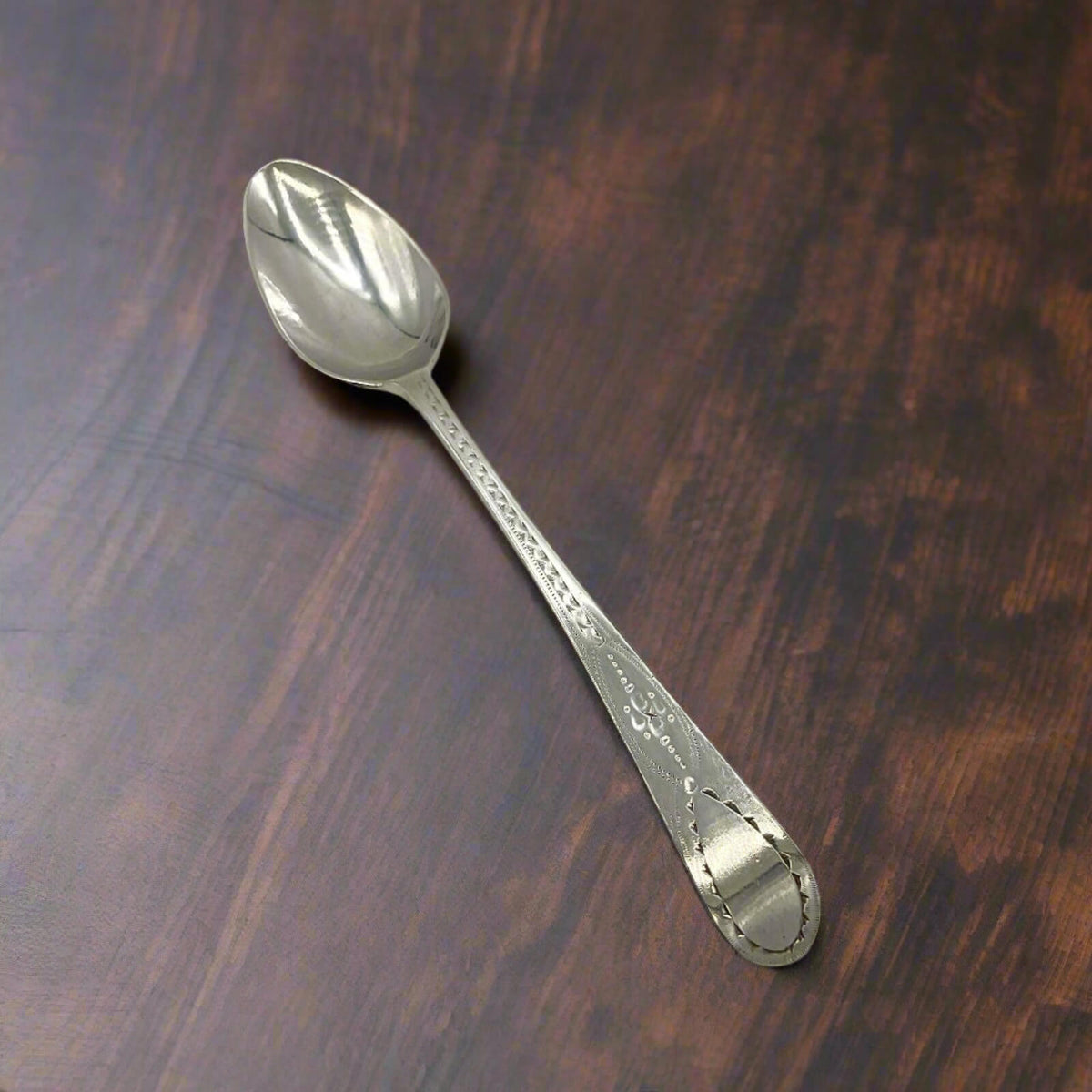 Decorative silver spoon on a wooden surface