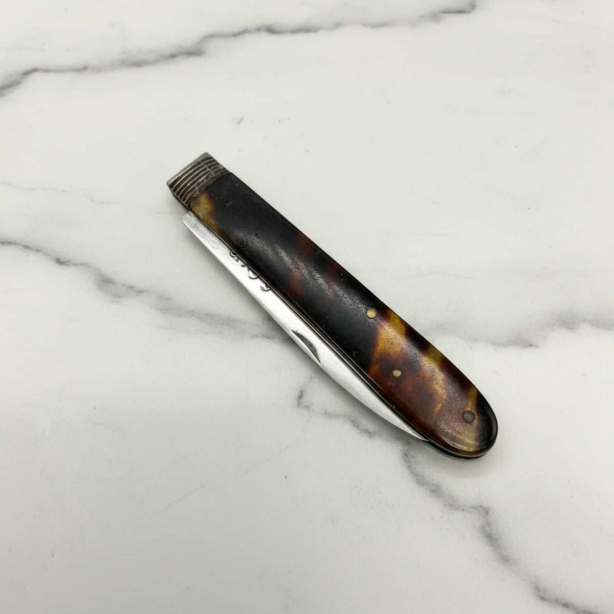 Antique 1819 Sterling Silver Fruit Knife resting on a white marble surface.