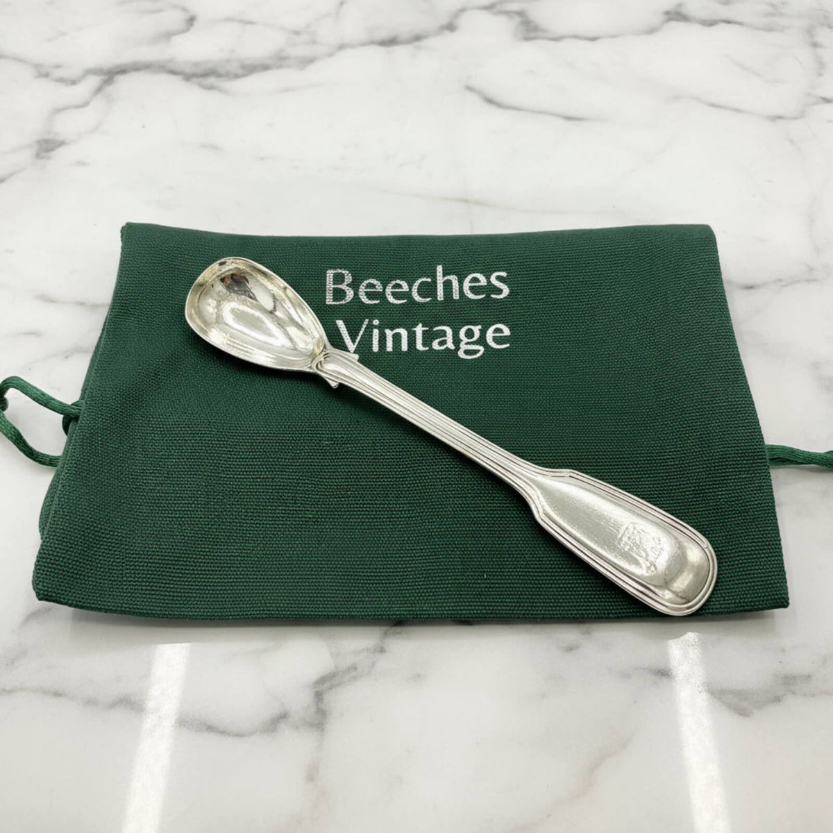 Antique 1835 Sterling Silver Mustard Spoon on a green bagon marble