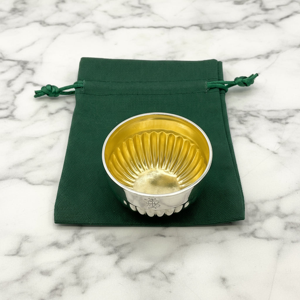 Glided silver Victorian salt on a green gift bag and white background 
