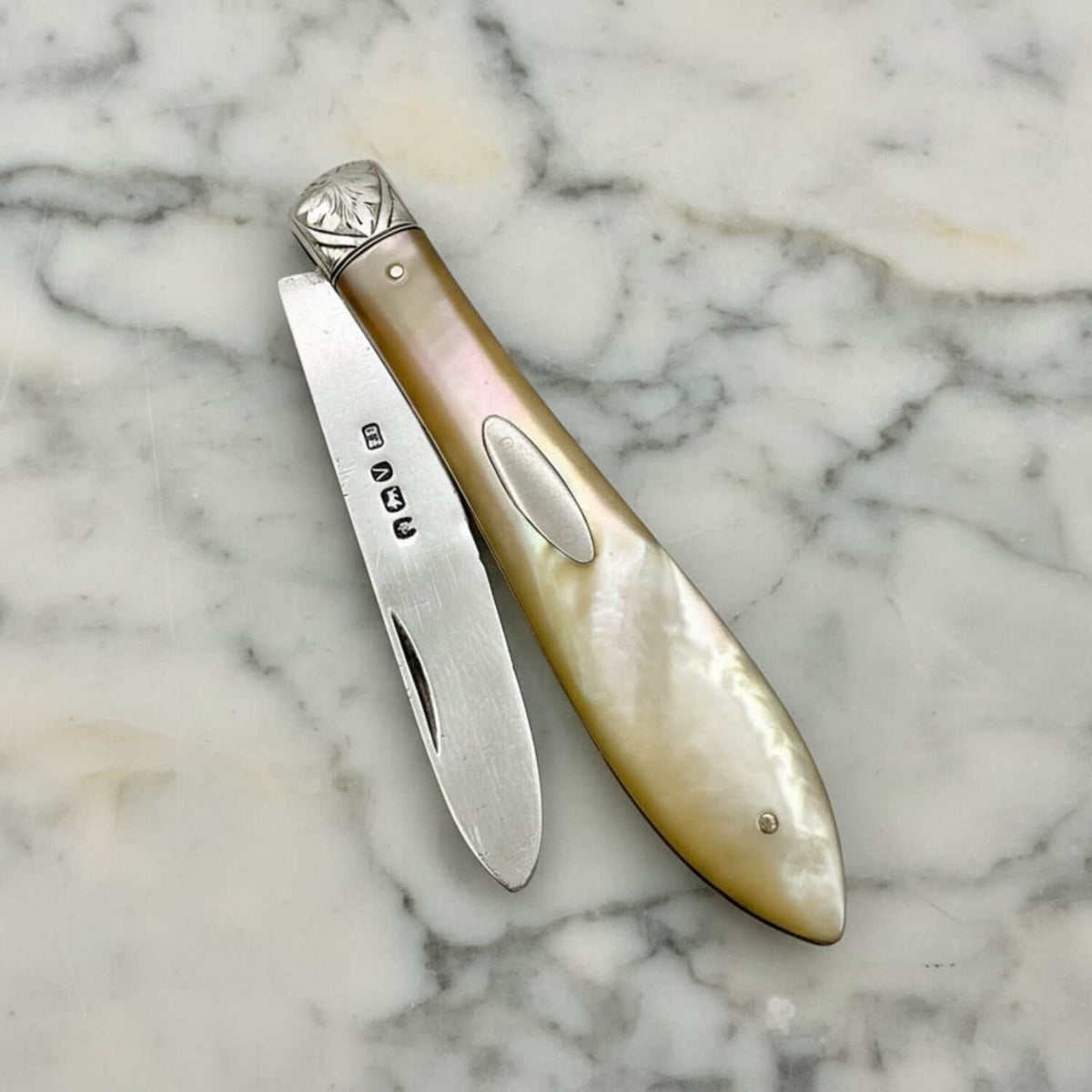 Foldable knife with decorative handle on a marble surface