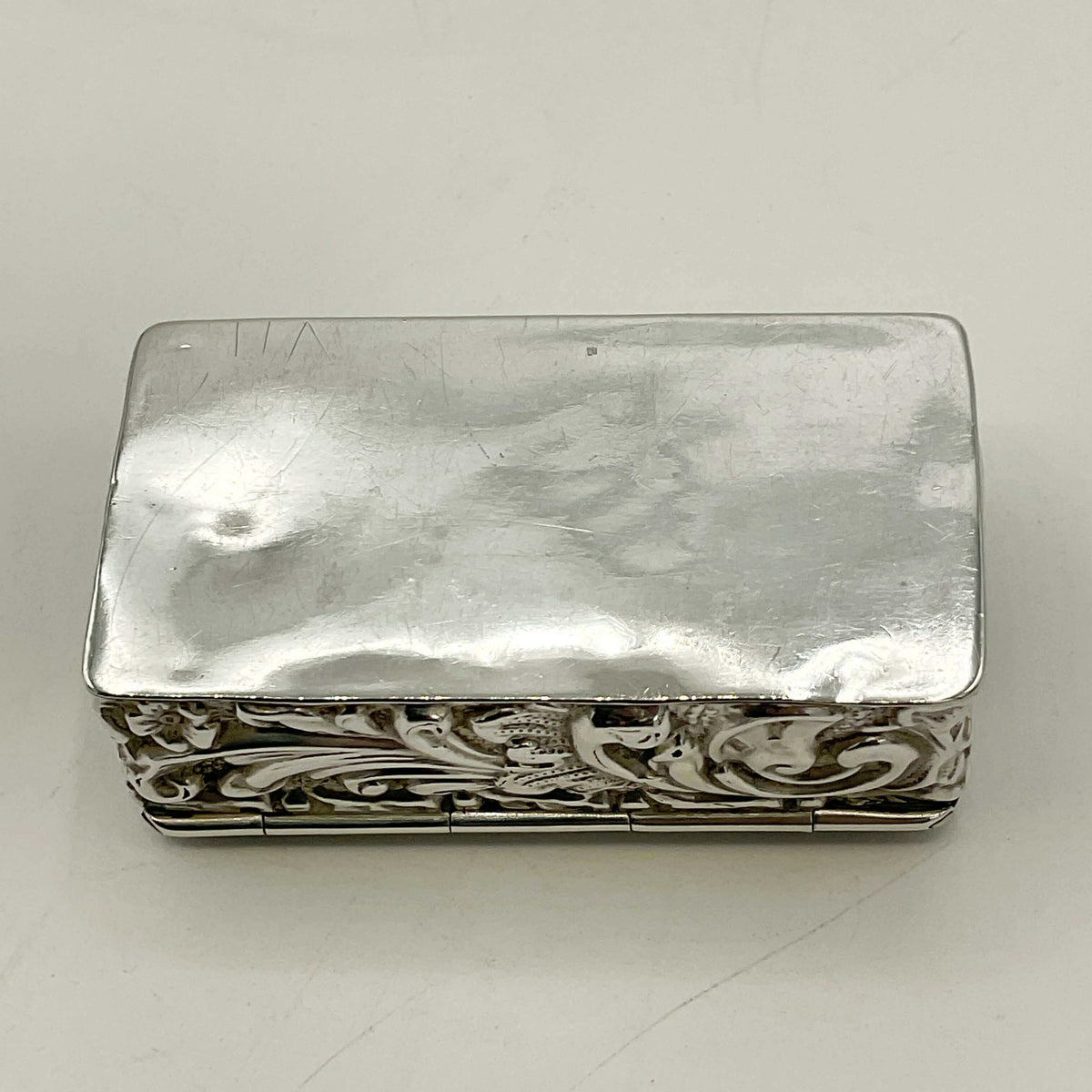 Silver decorative box with intricate patterns on a white background