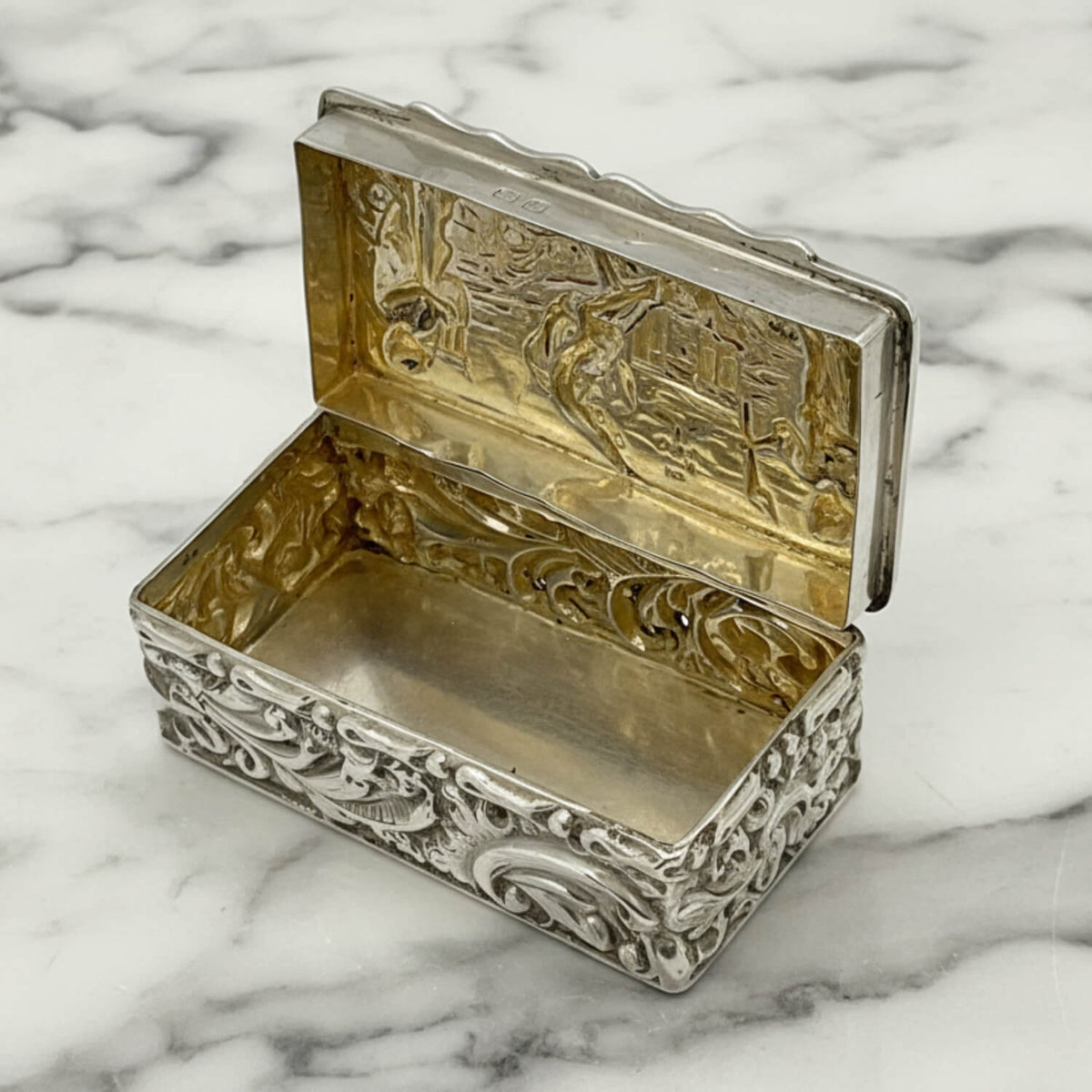 Decorative silver and gold box on a marble surface