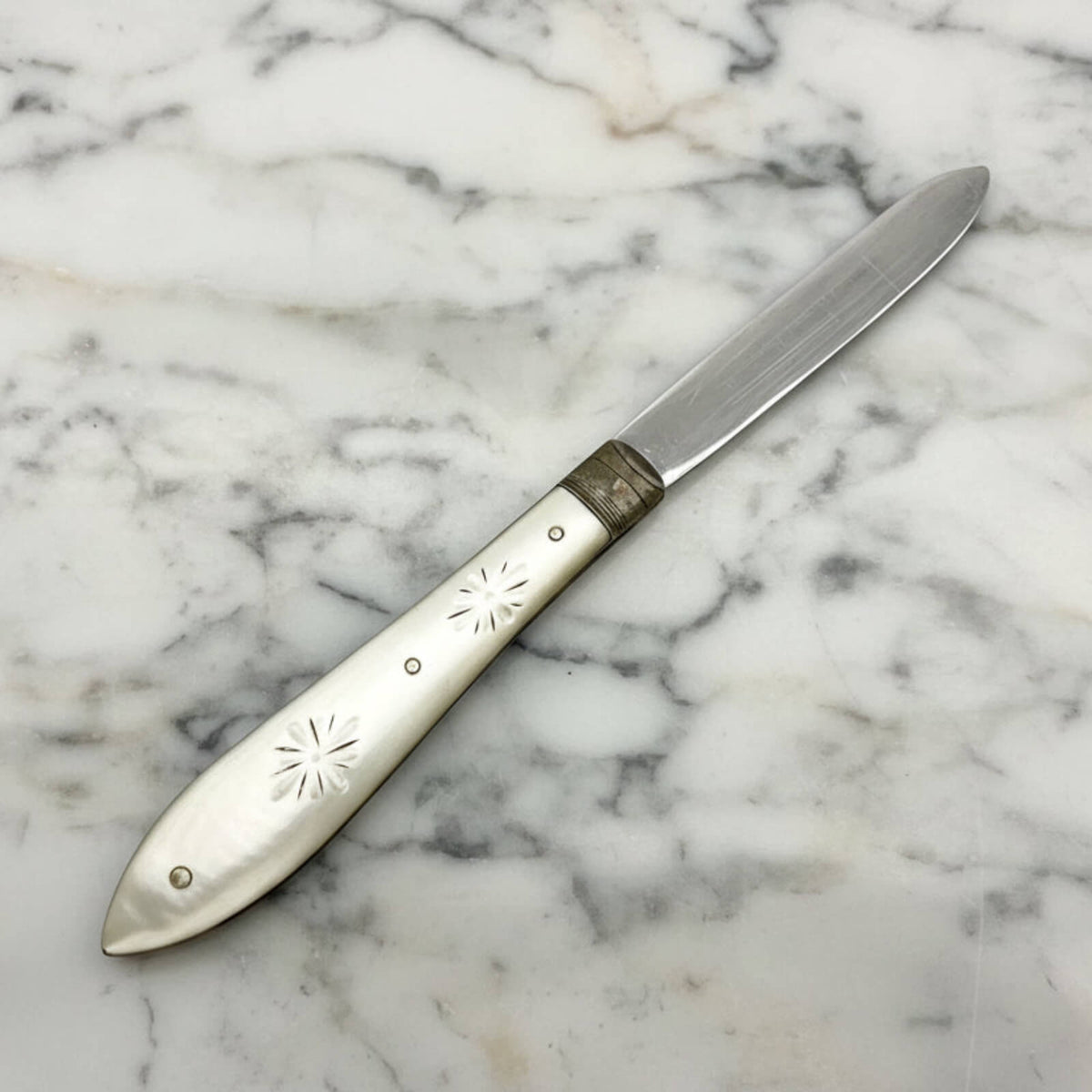 Decorative knife with engraved handle on a marble surface