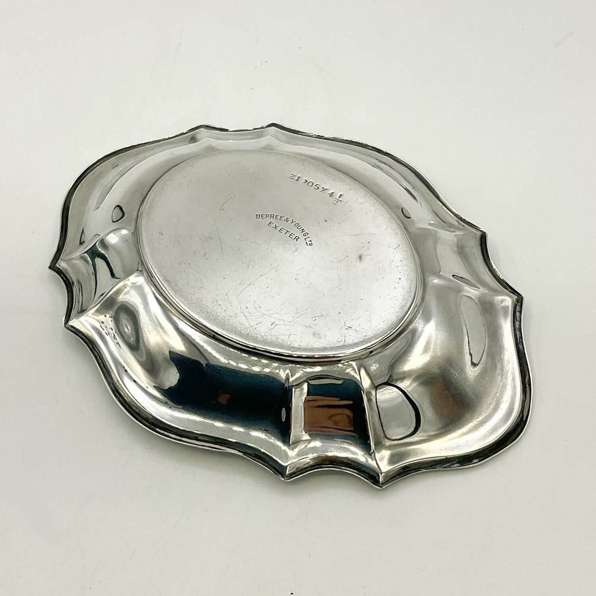 Antique silver pin tray with a scalloped rim, photographed from above on a white background.