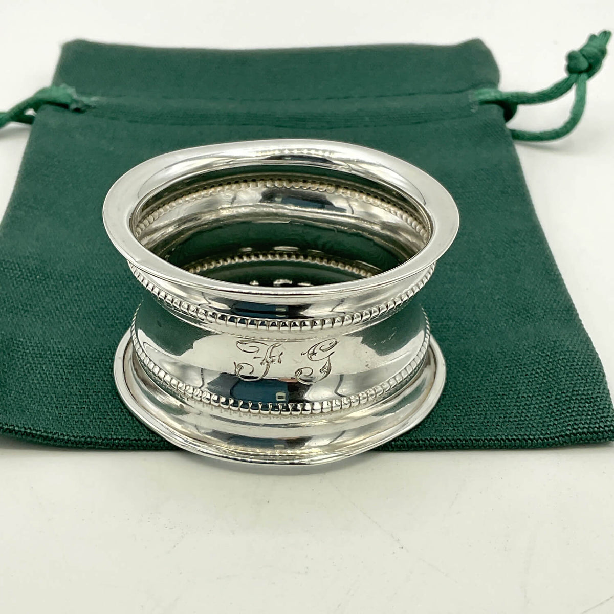 Antique 1912 Sterling Silver Napkin Ring on a green gift bag