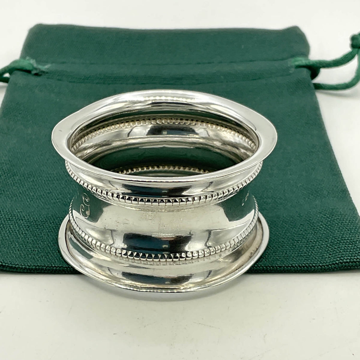Antique 1912 Sterling Silver Napkin Ring on a green bag
