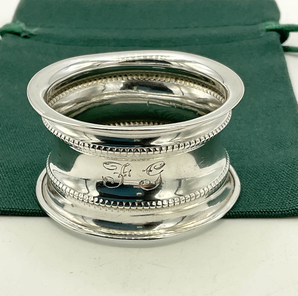 Antique 1912 Sterling Silver Napkin Ring on a green gift bag