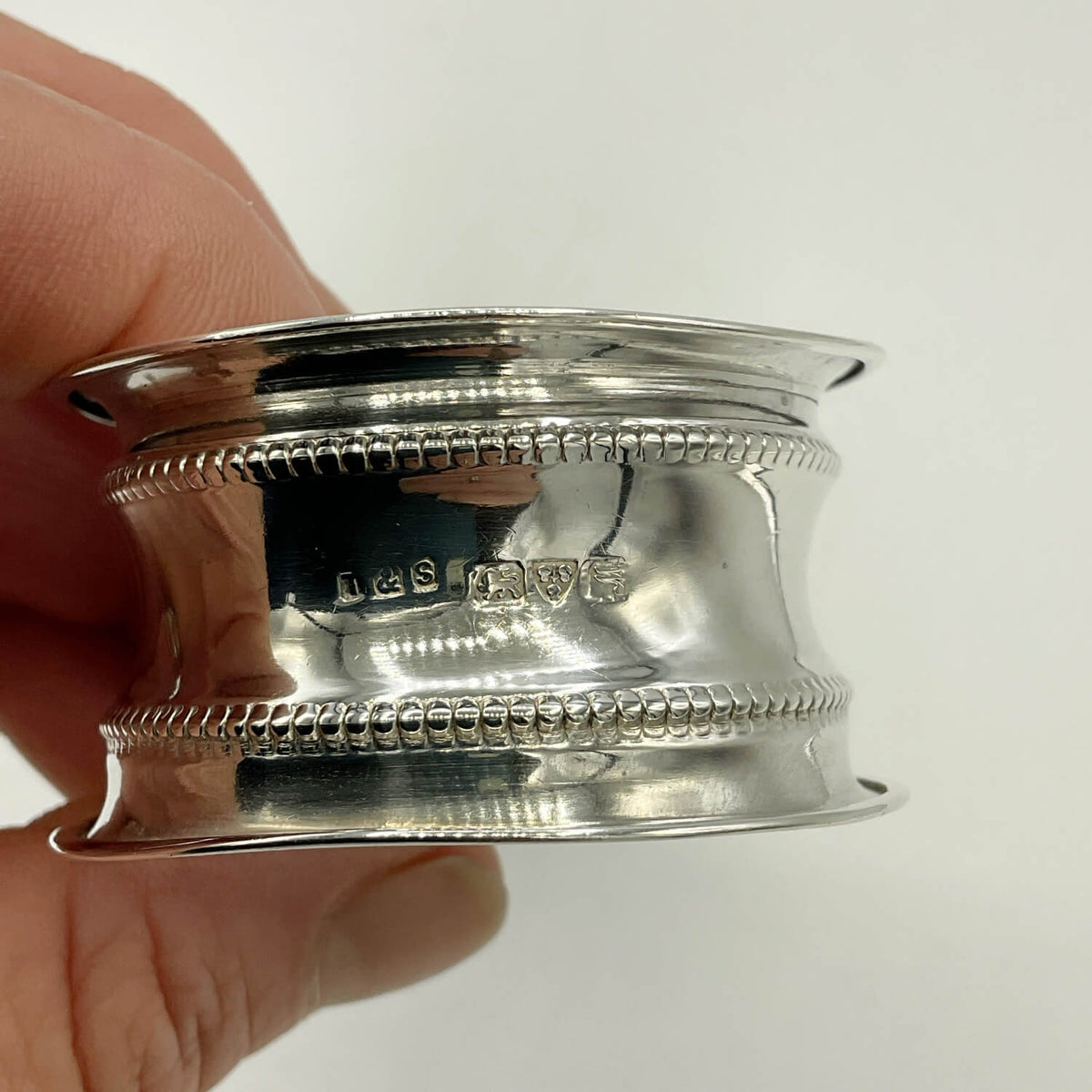 Antique 1912 Sterling Silver Napkin Ring showing hallmarks held in fingers