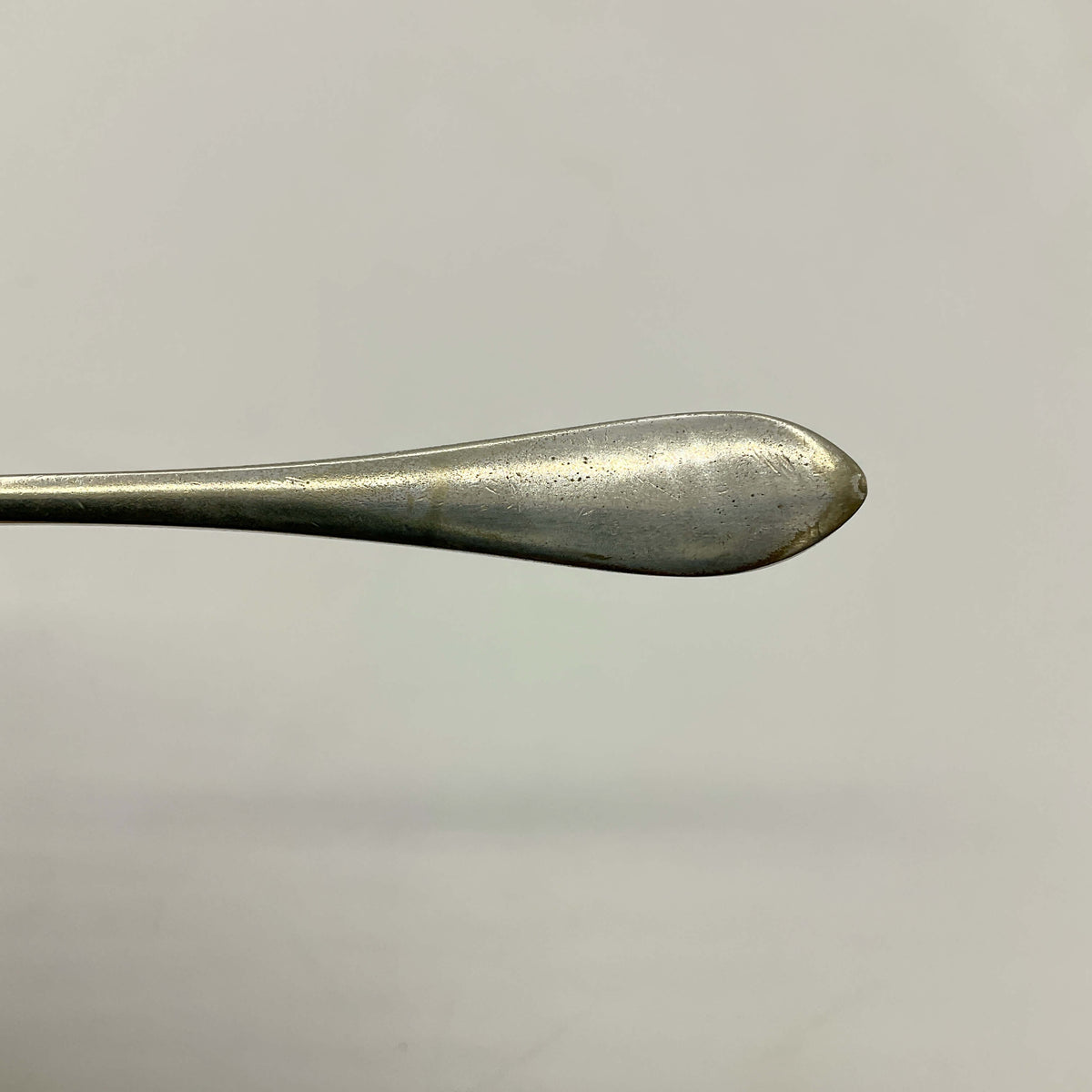 Close-up of a silver plated butter knife on a light gray background