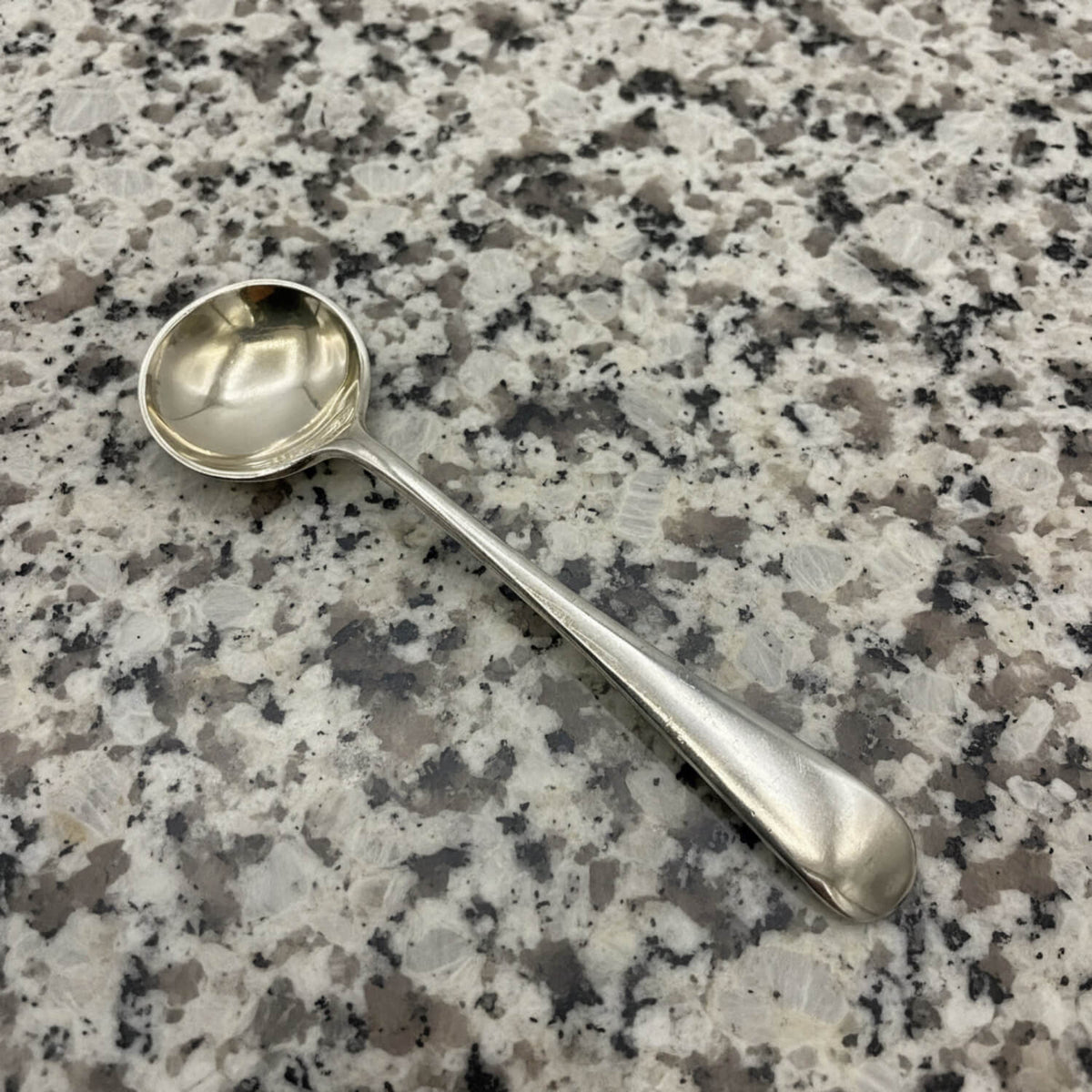 Silver spoon on a speckled granite surface