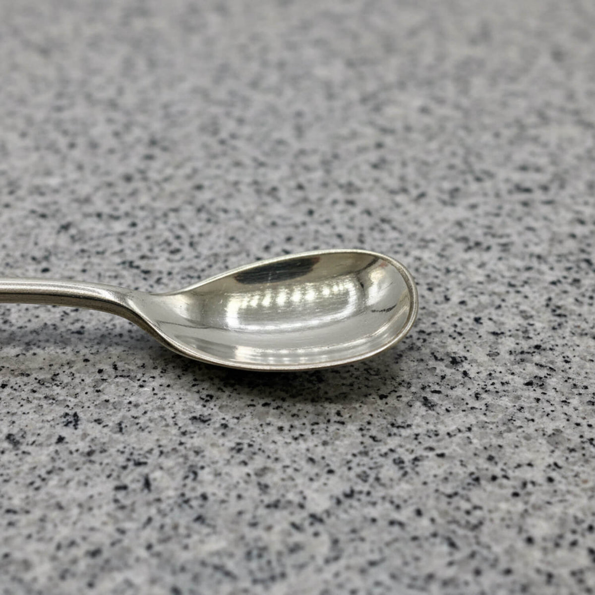 Silver spoon on a grey speckled surface