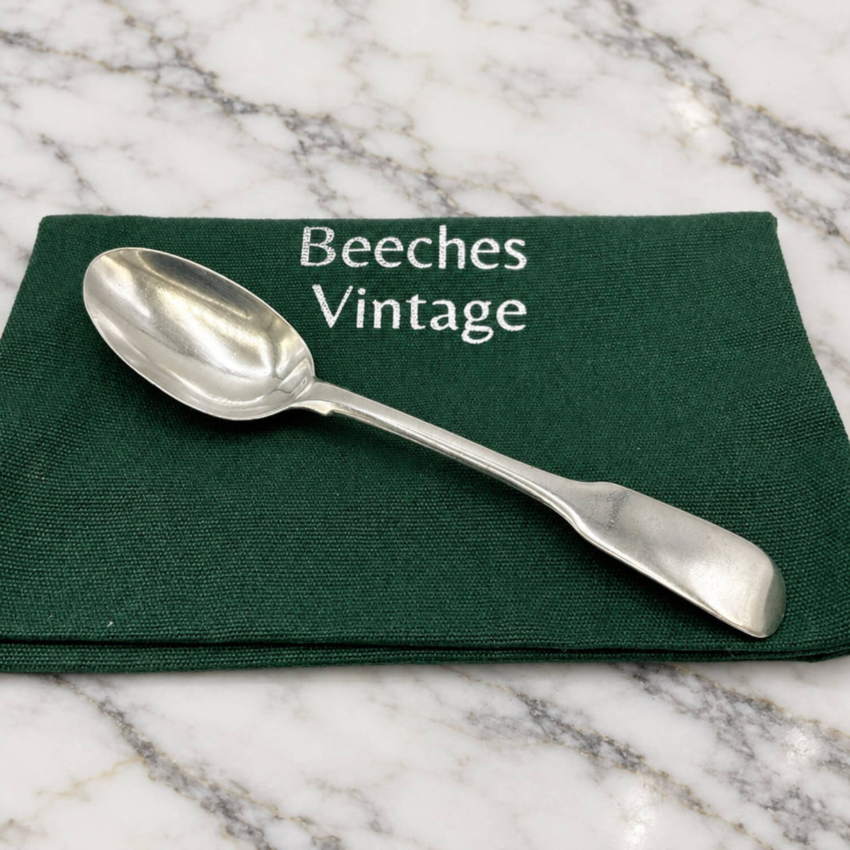 Antique Victorian Sterling Silver Teaspoon on a gift bag and marble surface