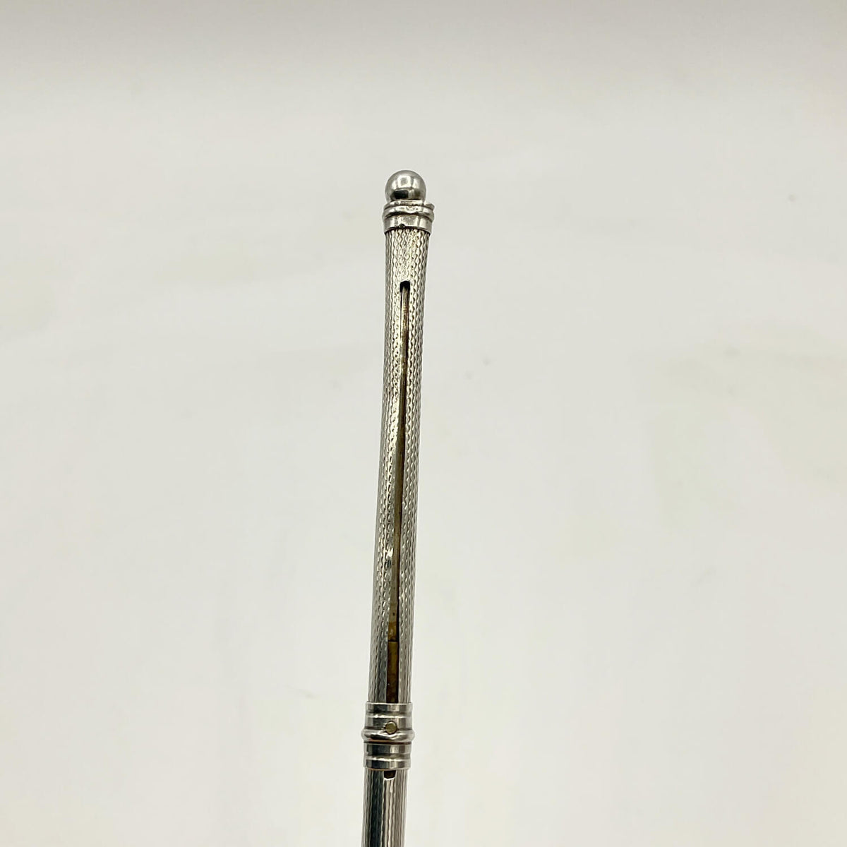 A close-up of a Art Deco Sterling Silver Cocktail Whisk set against a plain off-white background.