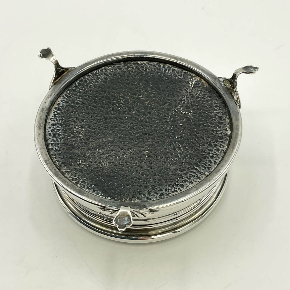 Base of a vintage silver box photographed on a plain white background.