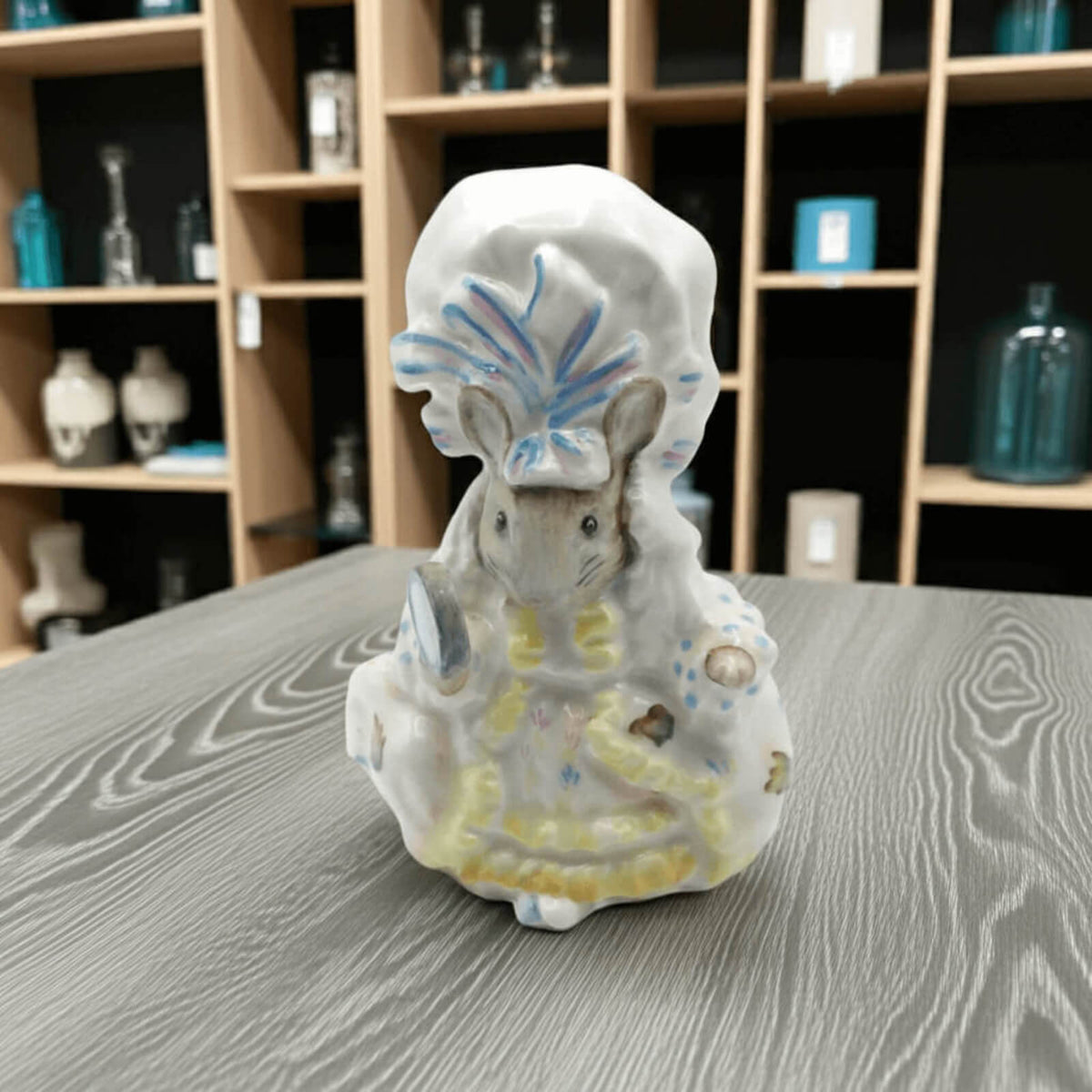 Decorative figurine of a mouse with a headdress on a wooden surface