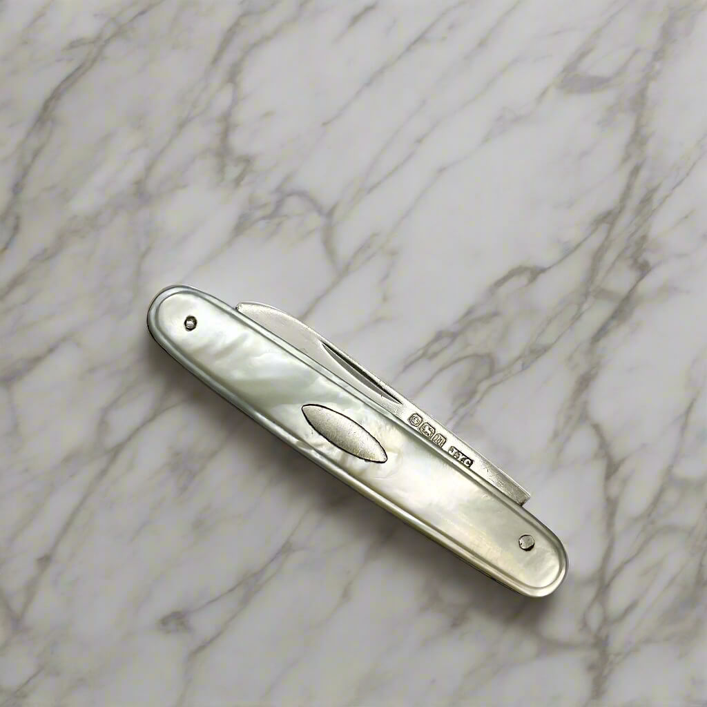 Silver pocket knife on a marble surface