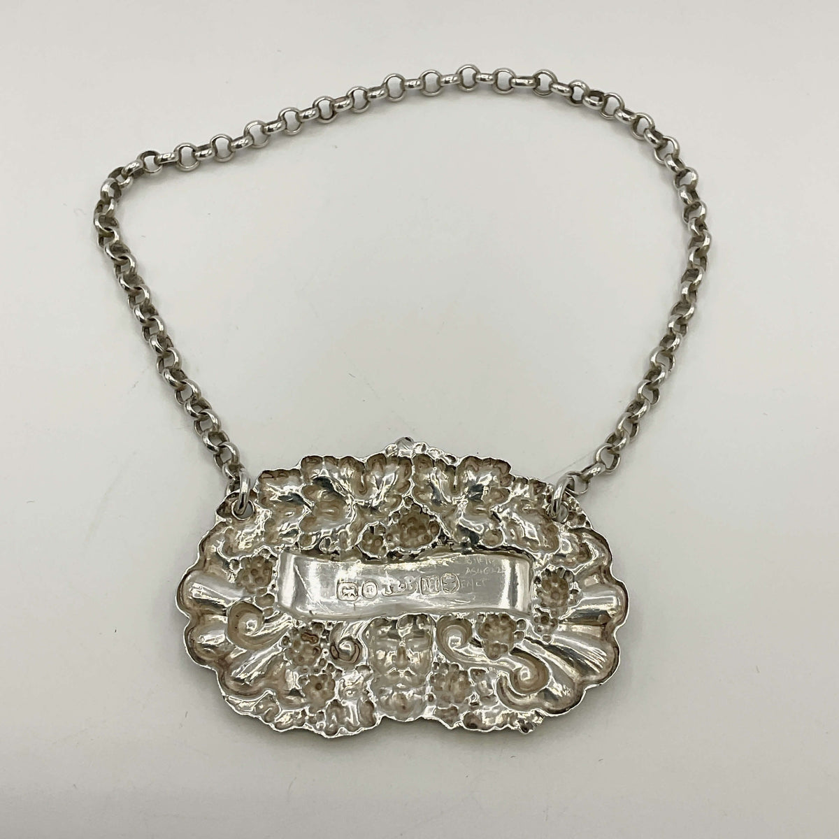 Back of silver decanter label on a white background 