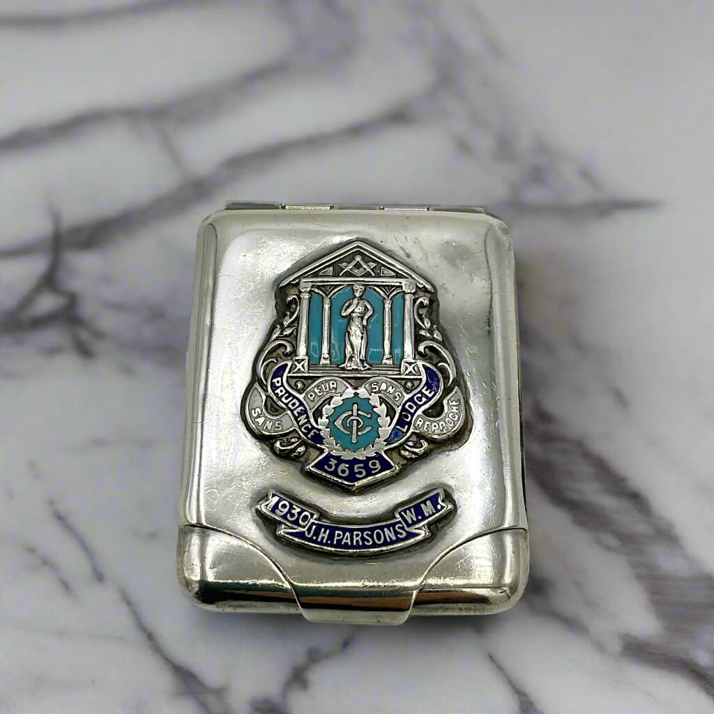 Silver matchbook case with Mason emblem on a marble surface
