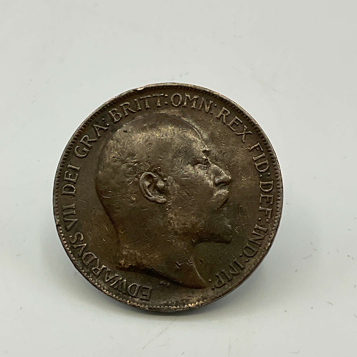 Antique coin with a profile of Edward VII on a white background