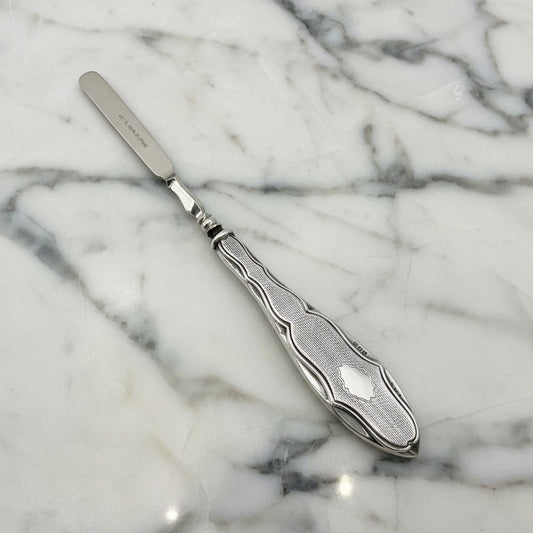 Silver cuticle pusher on marble