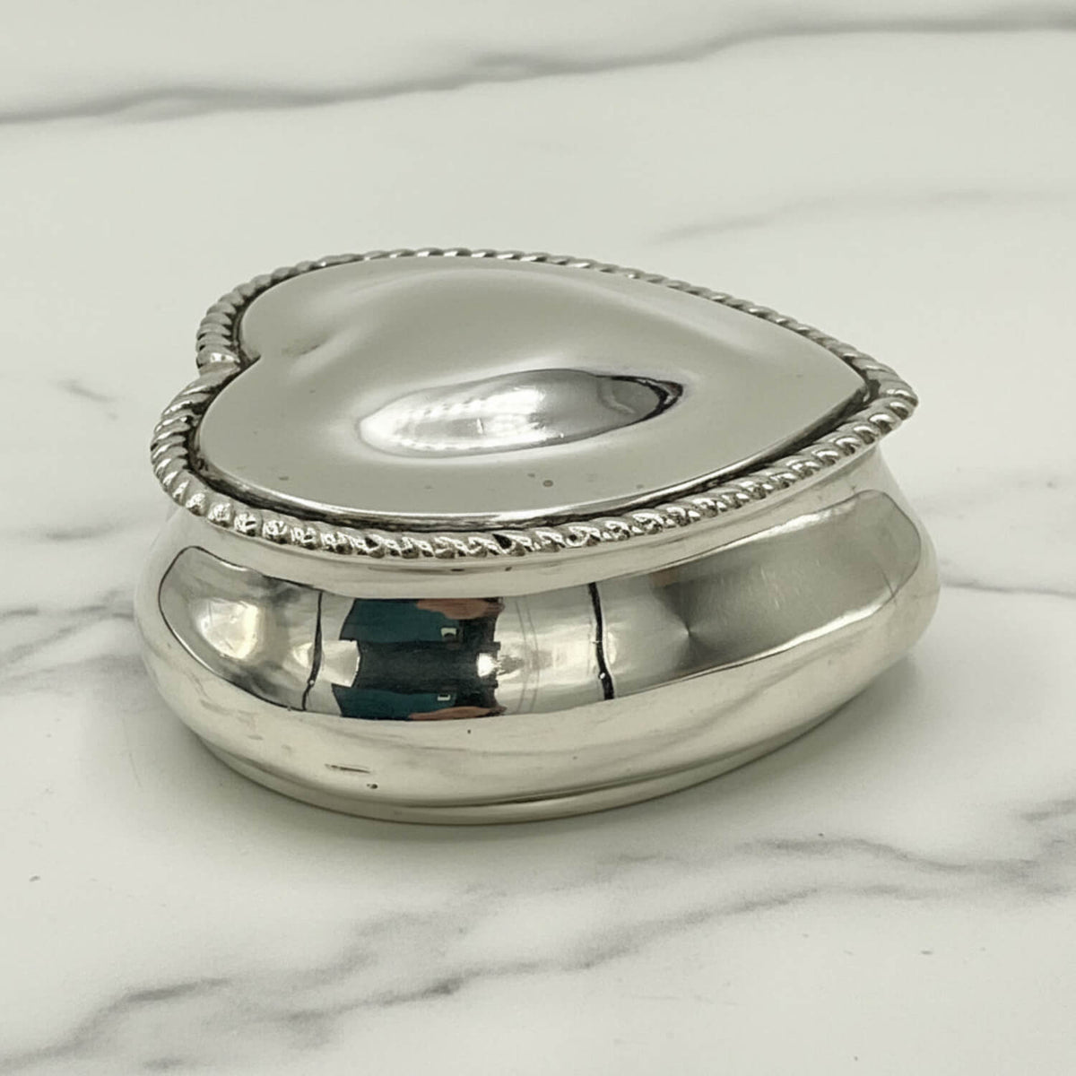 Antique sterling silver heart-shaped jewellery box with intricate detailing, crafted by Beeches Vintage.