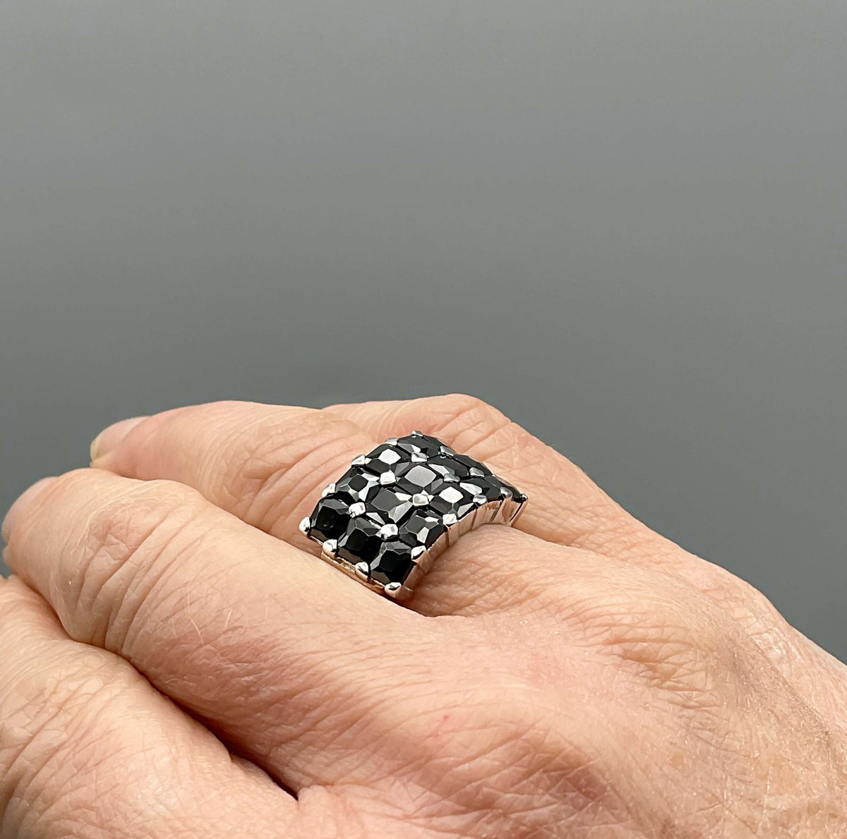 Silver ring with black cubic zirconia stones, vintage style from Beeches Vintage, showcasing intricate design and sparkling gemstones.