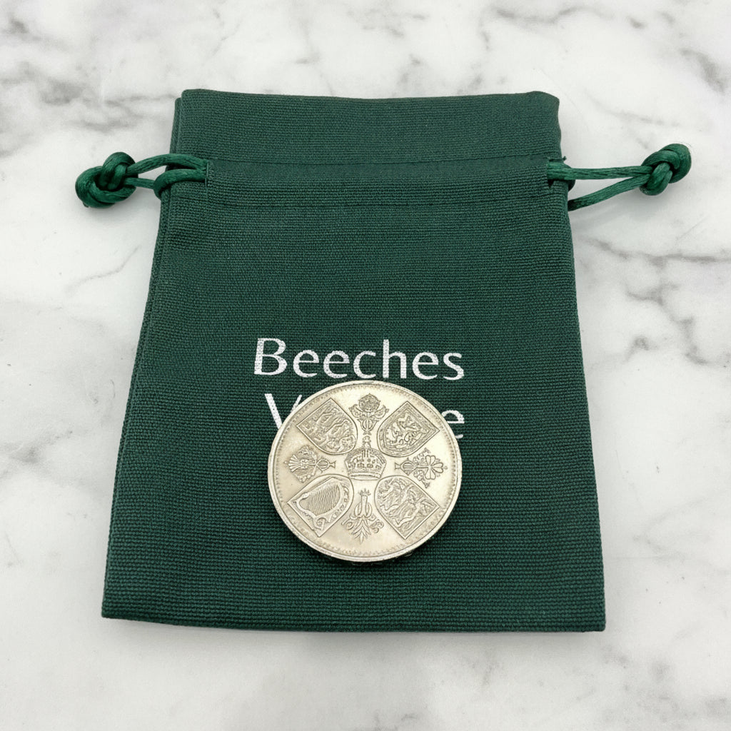 1953 Queen Elizabeth II coronation Coin in a green cotton bag on a marble surface