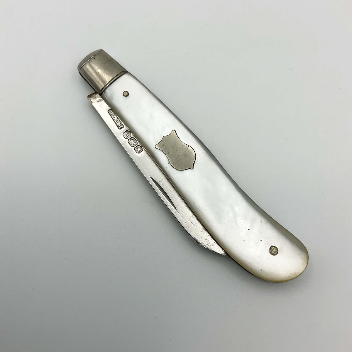 Vintage 1925 Beeches Vintage sterling silver fruit knife with ornate handle and blade design, displayed on a wooden surface.