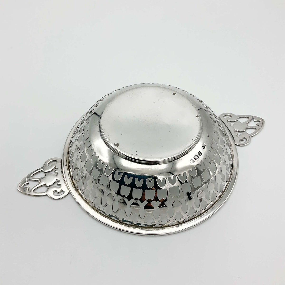 Base of silver bowl with handles showing hallmarks on a white background
