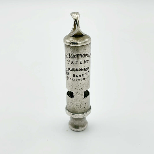 Antique police whistle from Beeches Vintage, vintage metal accessory with a classic design, resting on a neutral background.