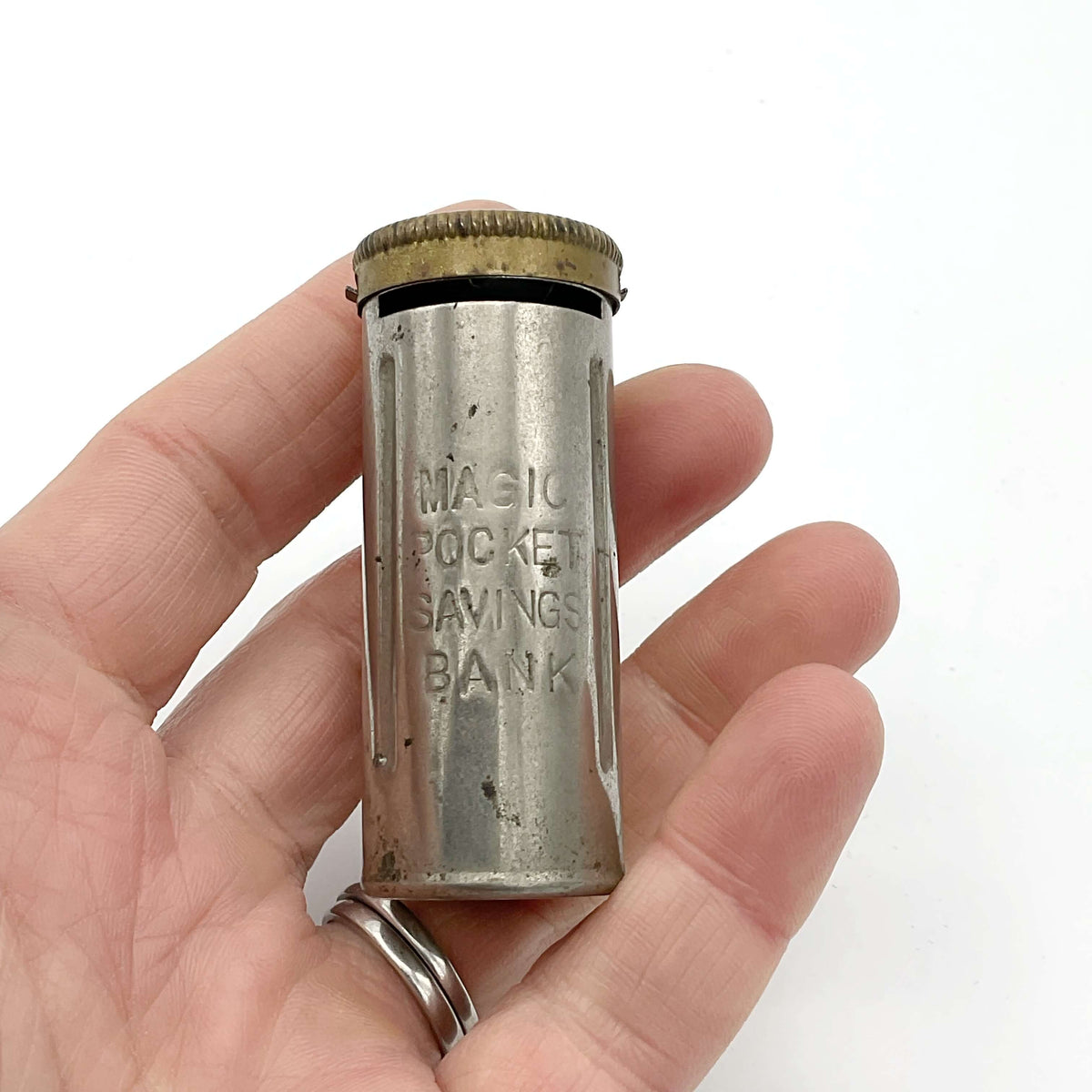 Vintage coin holder called the Magic Pocket Savings Bank held in a hand