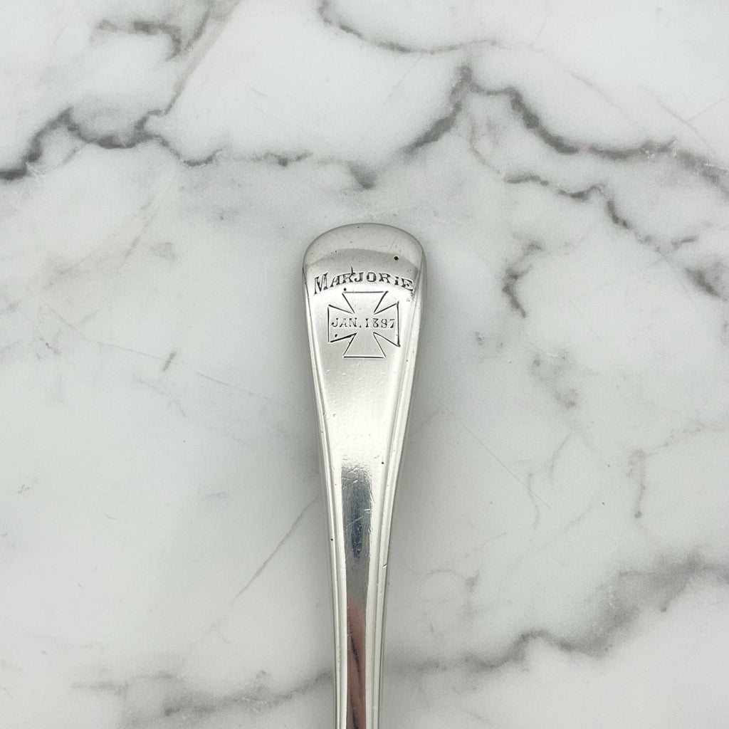 Marjorie Jan 1897 in a cross on a spoon handle on a marble wotrktop