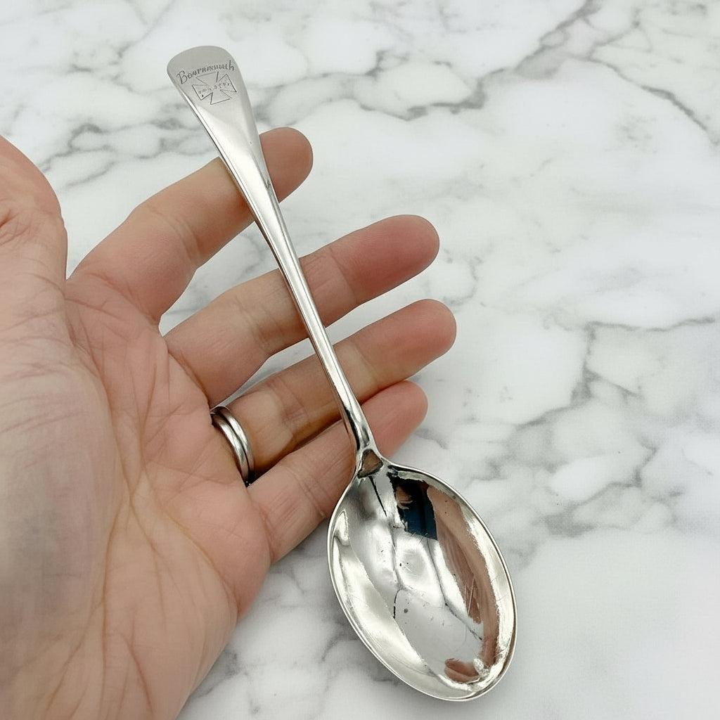 Antique Silver plated spoon with Marjorie on the handle In a hand on a marble worktop