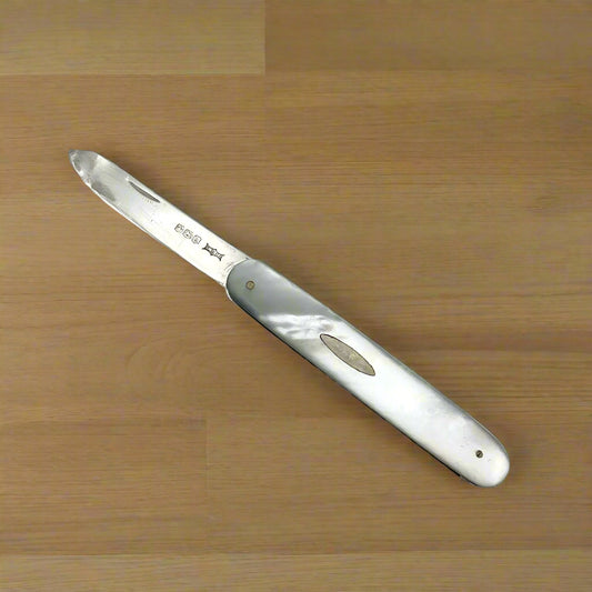 Silver fruit knife with a mother of pearl handle on a wooden worktop