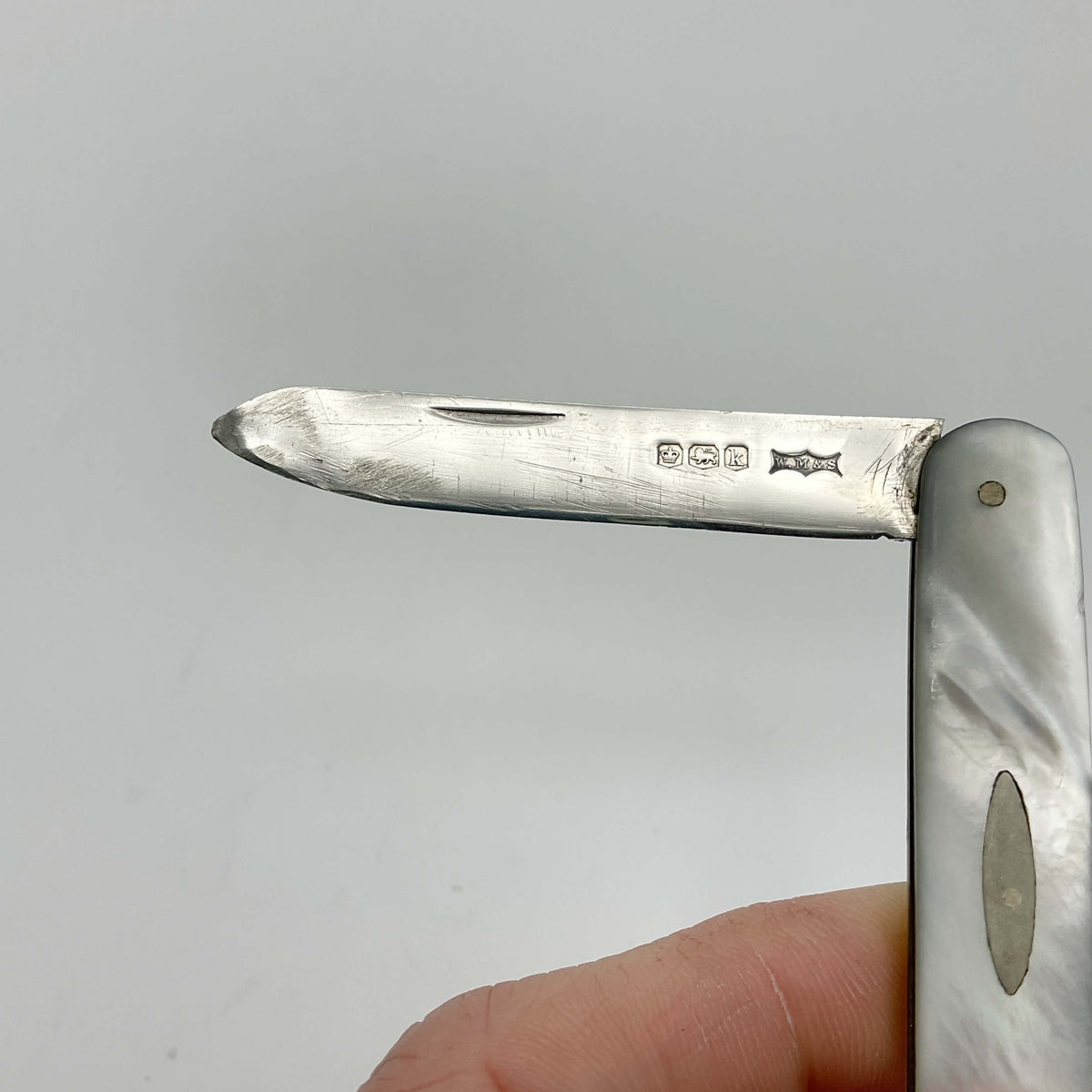 Silver fruit knife with a mother of pearl handle showing the hallmarks on a blade