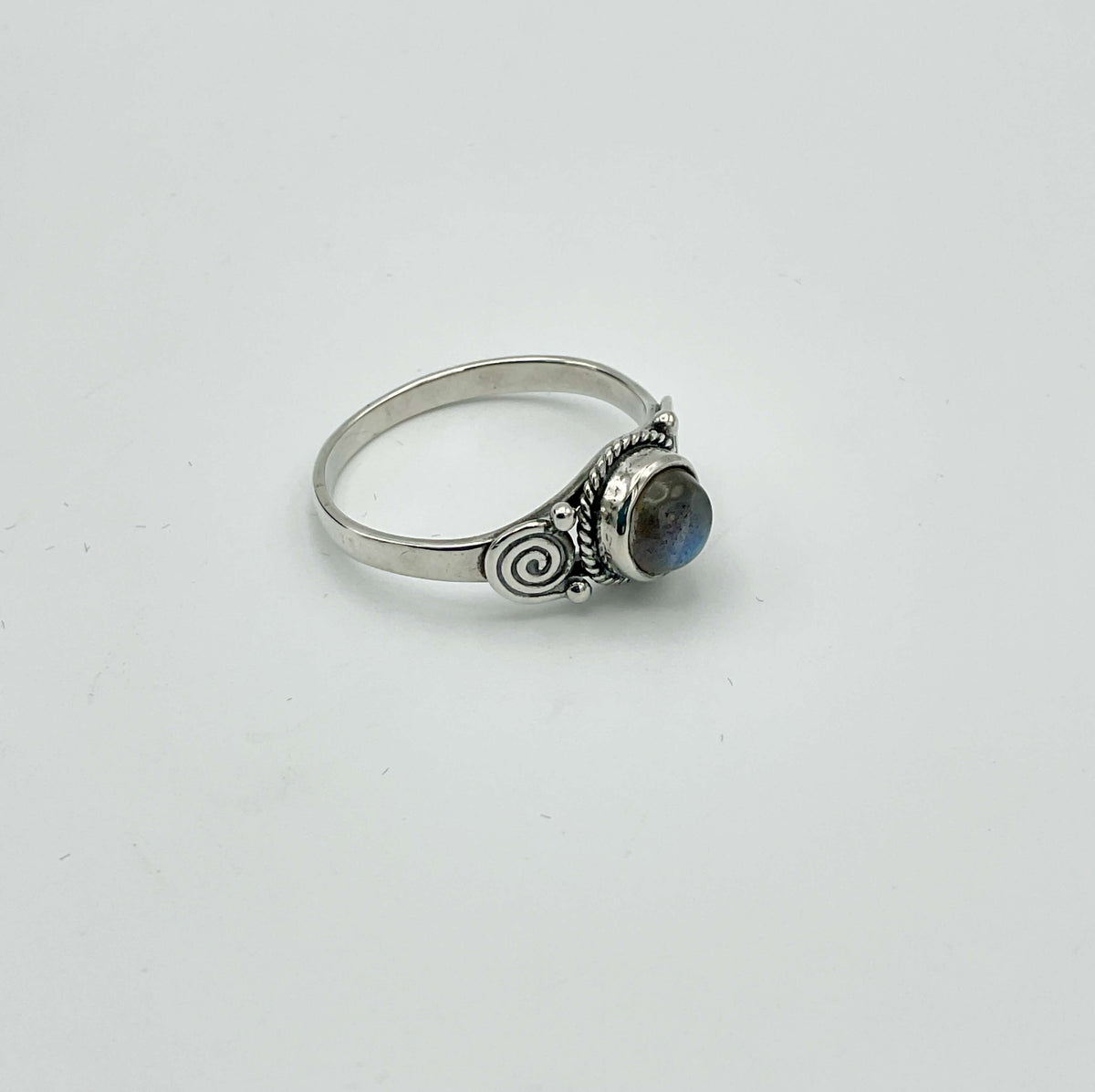Ornate moonstone silver ring with an ornate design on a white background 