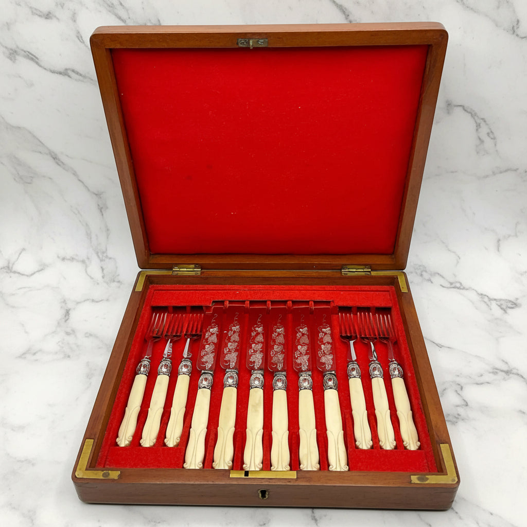 Antique silver plated dessert knives and forks with bone handles in a red lined wooden presentation box