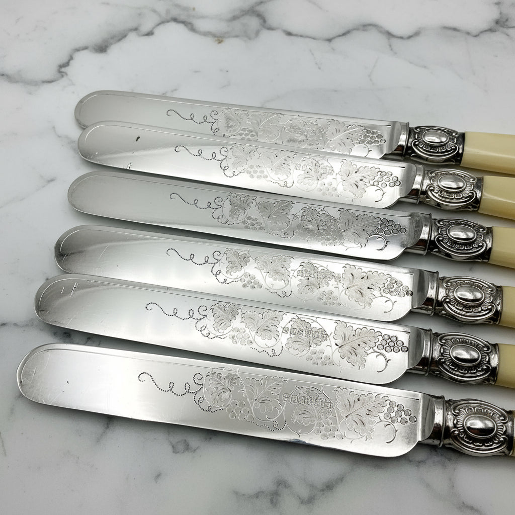 Shiny silver plated round knife blades with a grape and vine engraved design