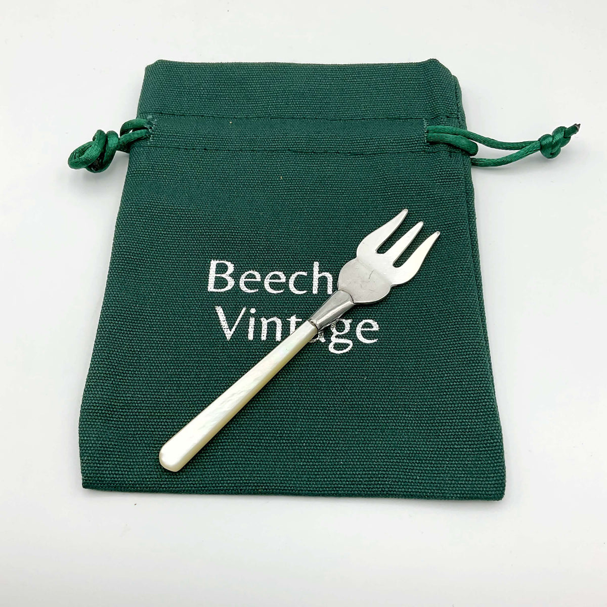 Small silver-plated pickle fork with a mother of pearl handle, featuring an olive fork design by Beeches Vintage.